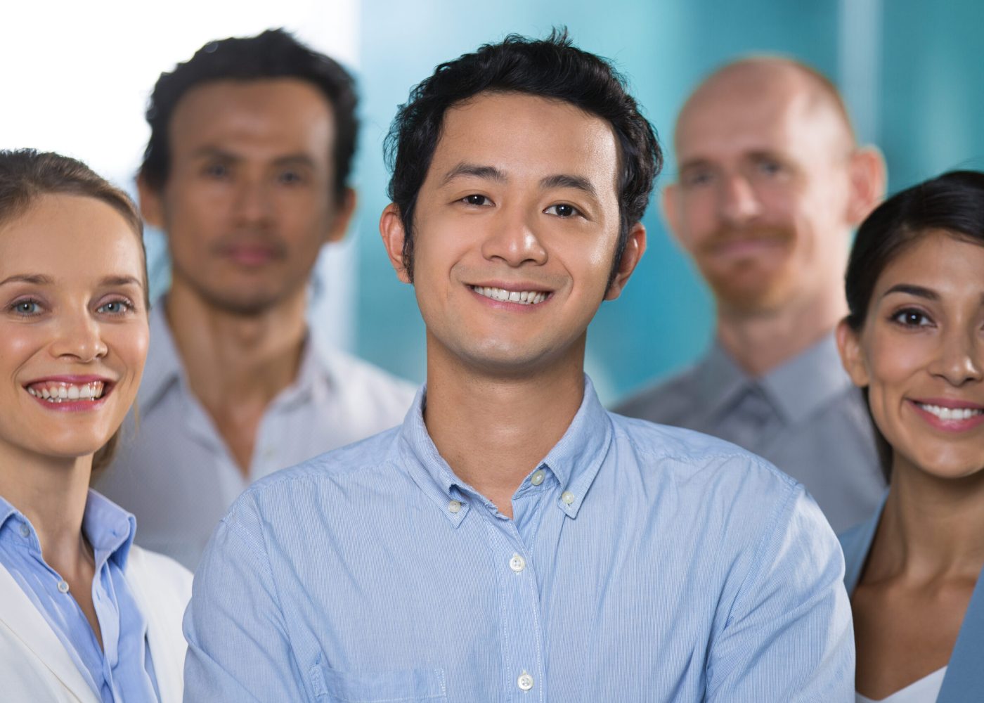 Smiling Asian male specialist working with professionals. Cheerful handsome Vietnamese businessman and his team looking at camera. Building successful business concept